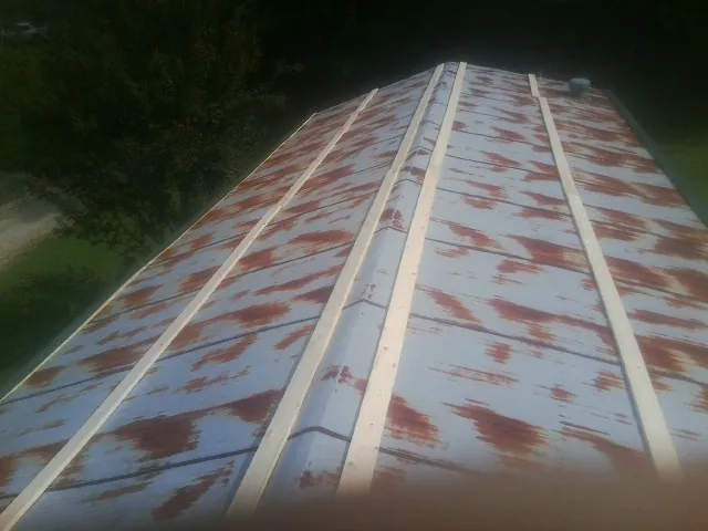 Rusted metal roof panels with new wood purlins before replacement — Storm Damage Roof Repair in Pine Level by Roofing Brothers