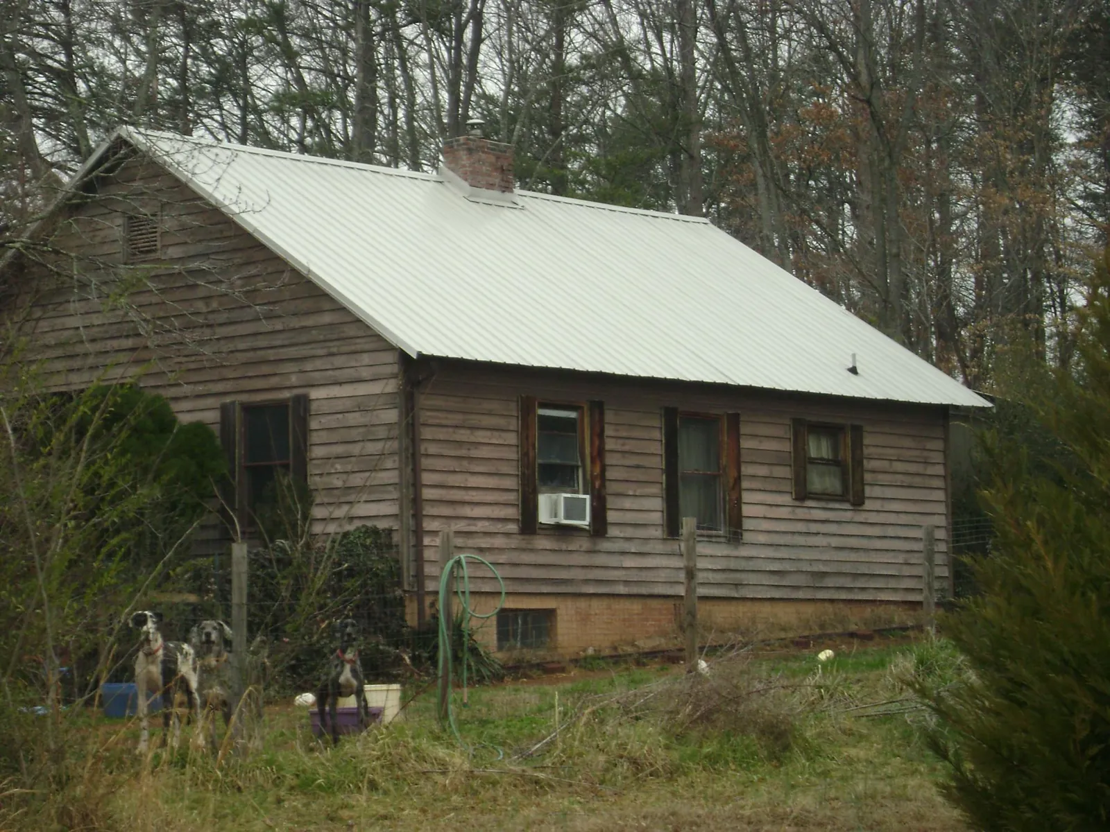 White metal roof on an old wood sided farmhouse, from a Metal Roof Installation job in Pine Level